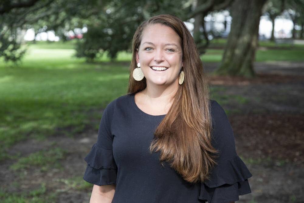 Headshot of Kelly McGinty wearing a black shirt and long brown hair